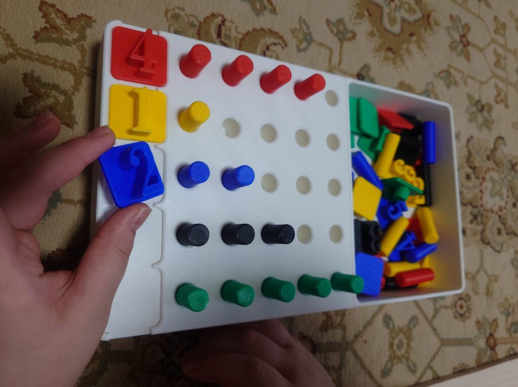 数と色のペグ差し課題を使う様子(ピンに合わせて数字ピースをはめる)