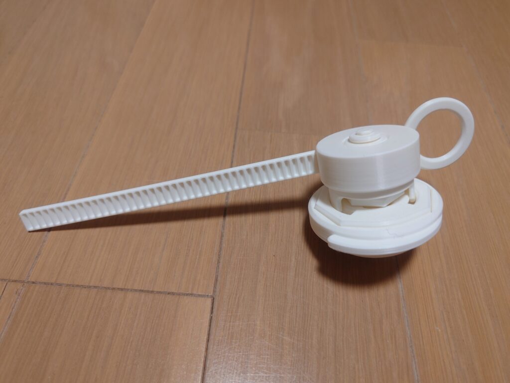 白いコマをランチャーに取り付け、引っ張り棒を差し込んだ状態の写真