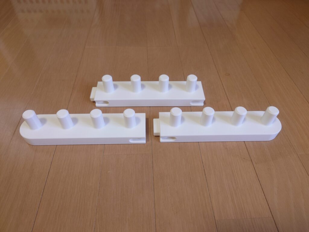 白い編み物の台を3つに分けて机に並べた写真。それぞれにペグが4本ずつ立ち、端に連結用の出っ張りとくぼみがある